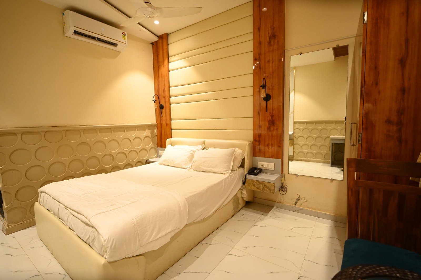 Deluxe room at Palm Springs Beach Resort Gorai with teak panelling and marble flooring