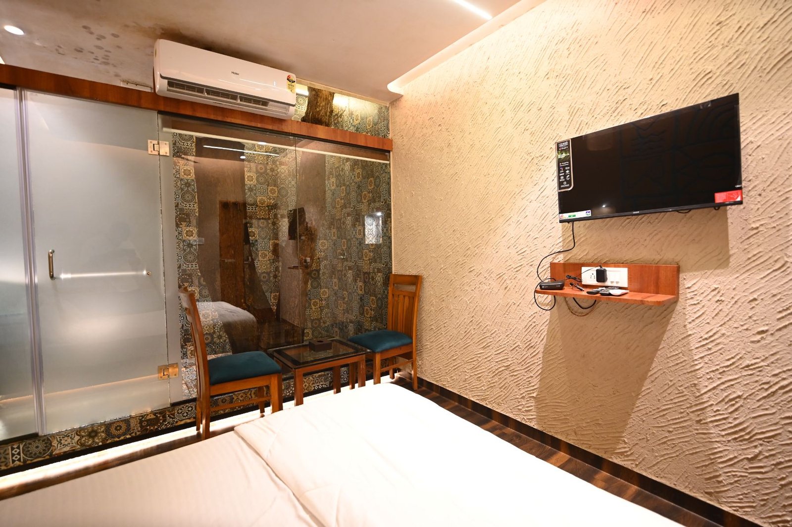 Nature's Vault room at Palm Springs Beach Resort Gorai, with a tree growing inside the glass walled bathroom