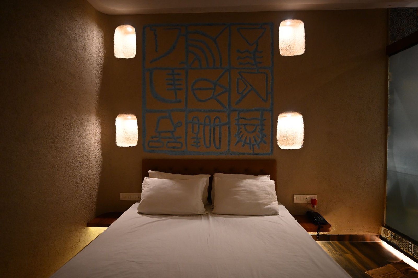 Nature's Vault bedroom with alcove lighting and blue mural, beach resort in Gorai