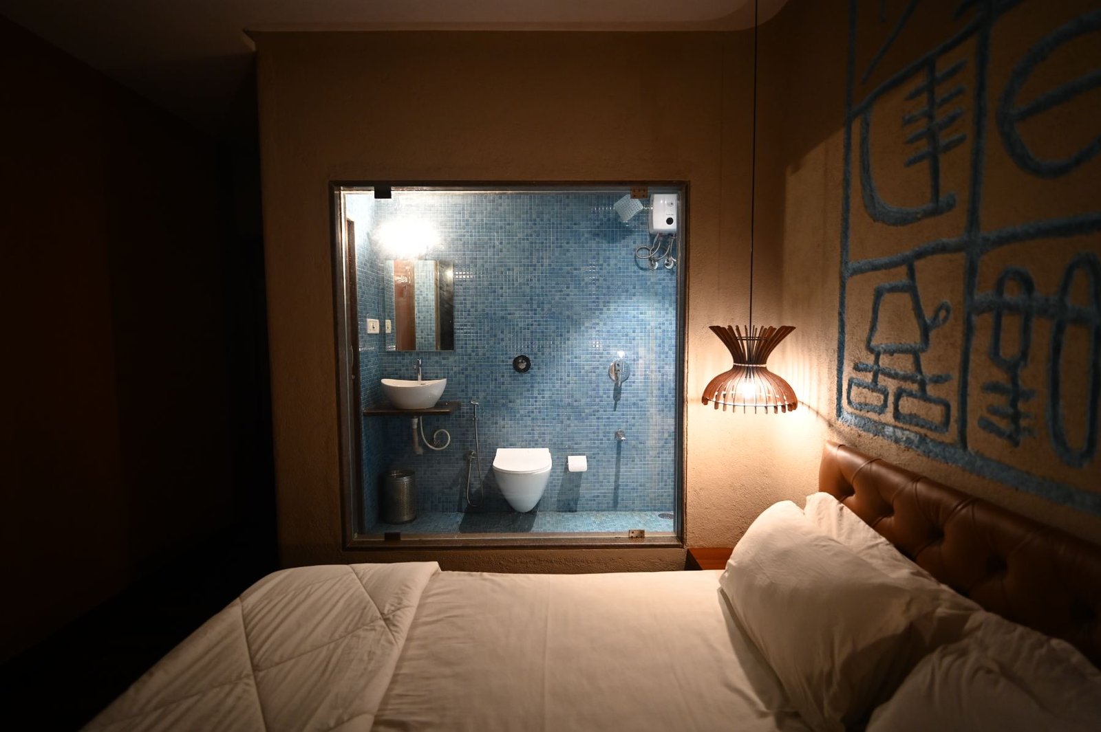 Semi Deluxe room with blue mosaic bathroom behind glass, resort near Gorai Beach Mumbai